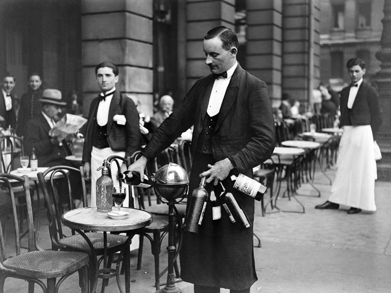 Ein Kellner, der im Jahr 1928 in einem Pariser Bistro Wein einschenkt.