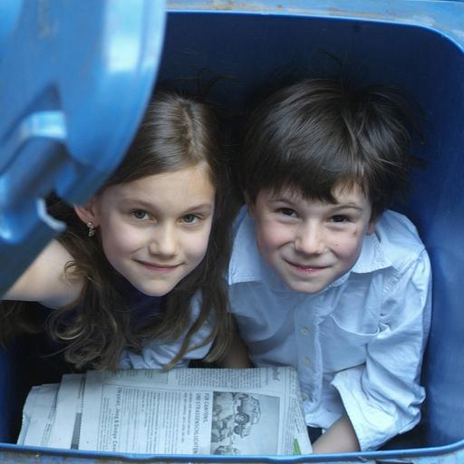 Kinder spielen in Papiermüll-Tonnen