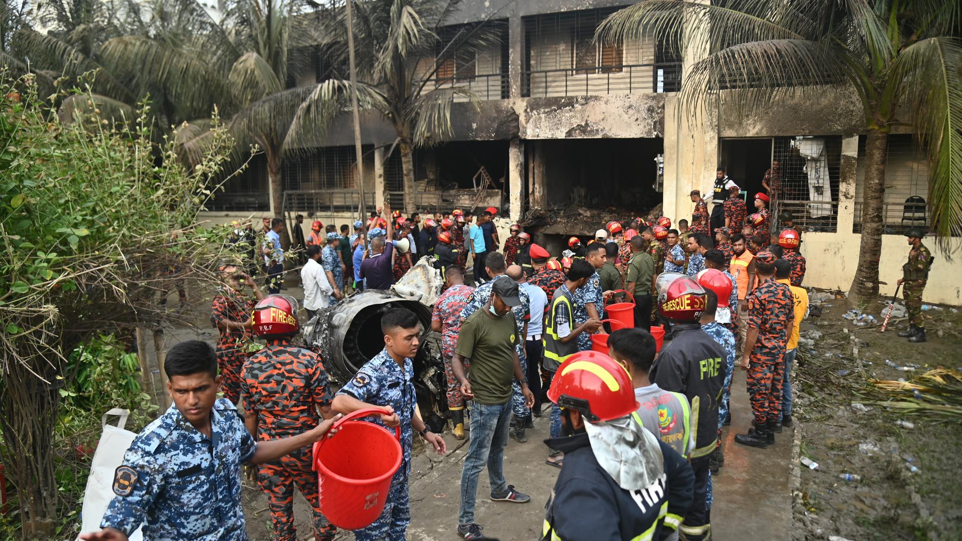 Angehörige der Armee und der Feuerwehr von Bangladesch beginnen mit Rettungsmaßnahmen, nachdem ein Flugzeug der Bangladesh Air Force in ein Gebäude des Milestone College gestürzt ist. 