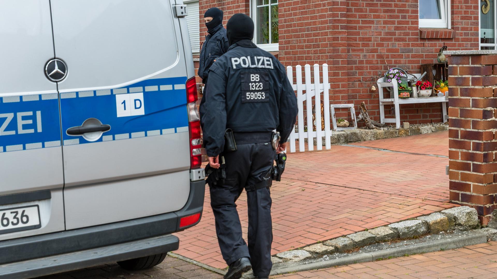 Polizisten durchsuchen ein Haus in Altdöbern in Brandenburg. 