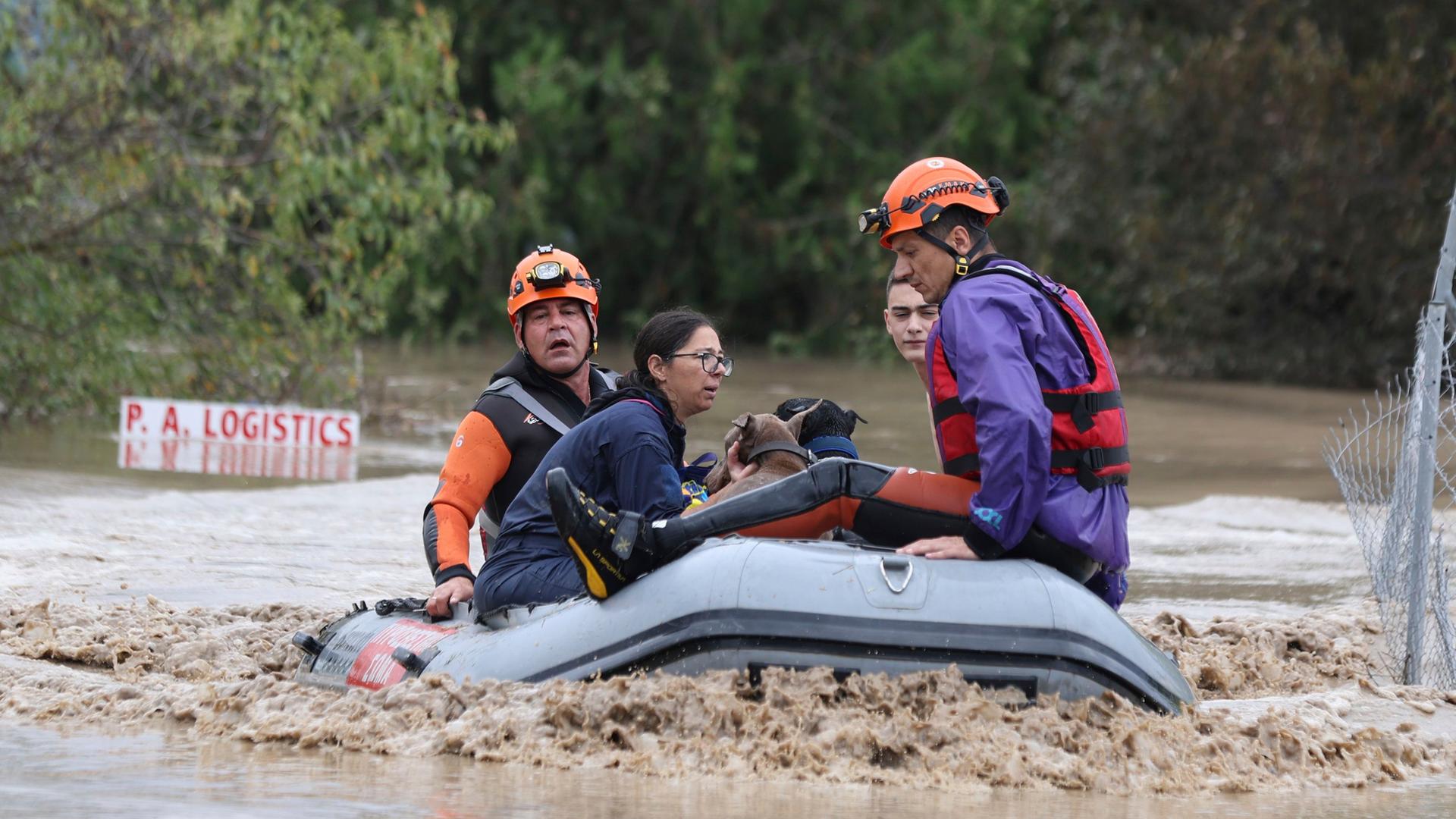 Griechenland, Larissa: Feuerwehrleute mit einem Schlauchboot evakuieren Menschen aus einem überfluteten Gebiet.