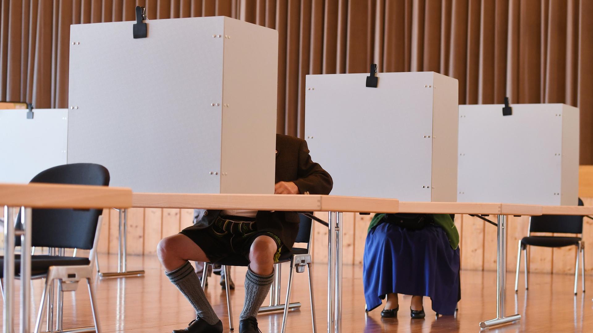 Ein Paar in bayerischer Tracht gibt seine Stimme bei der letzten Bundestagswahl 2021 in einem Wahllokal ab.