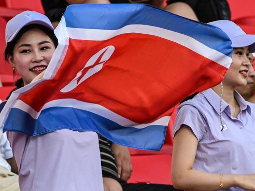Eine Zuschauerin mit nordkoreanischer Flagge bei der Partie Nordkorea gegen Taiwan während der Asian Games am 19. September 2023.