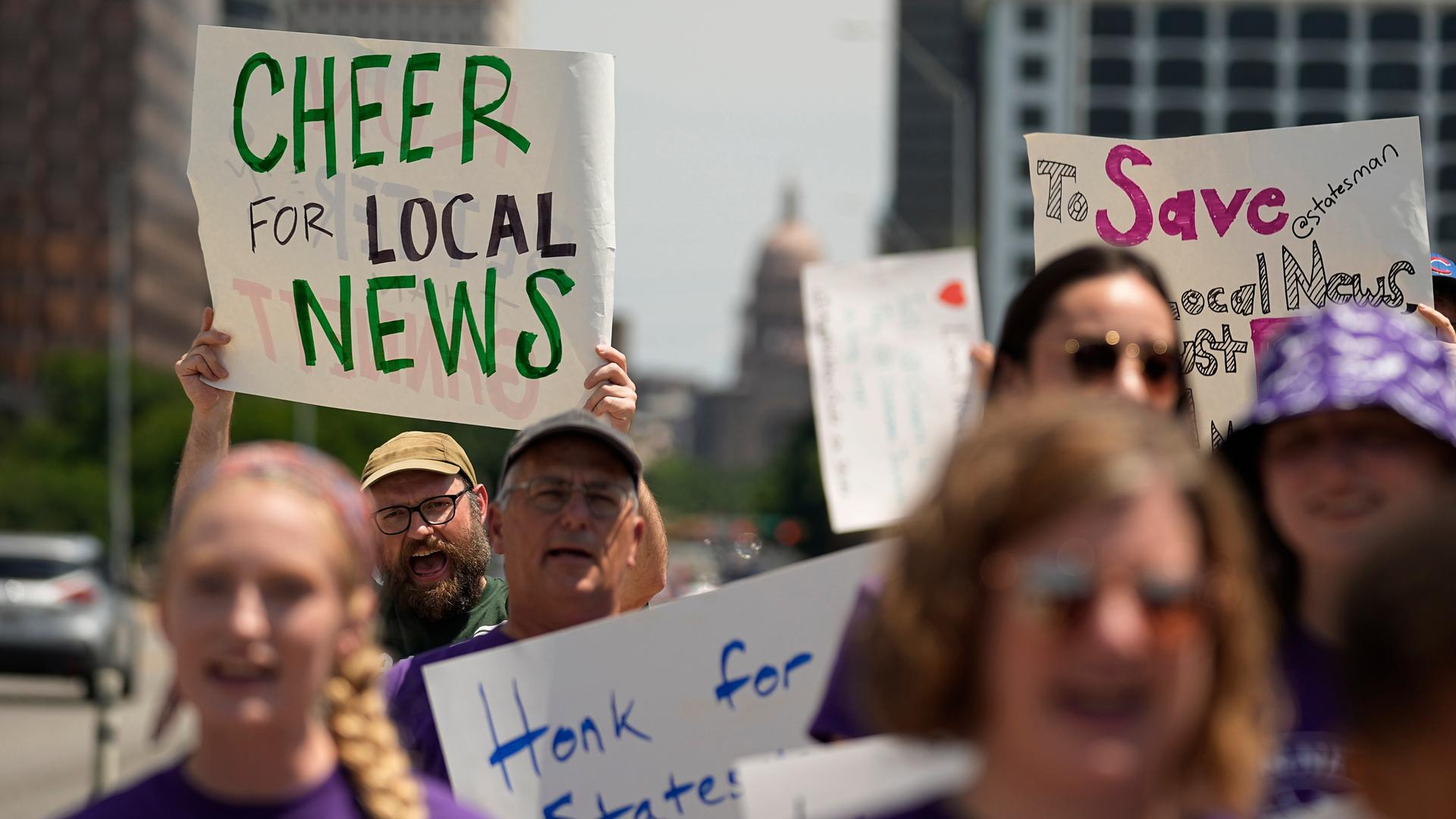 Beschäftigte des "Austin American Statesman" demonstrieren in Austin im US-Bundesstaat Texas. Ein Mann hält ein Schild mit der Aufschrift: "Cheer For Local News" - ein Hoch auf die Lokalnachrichten.