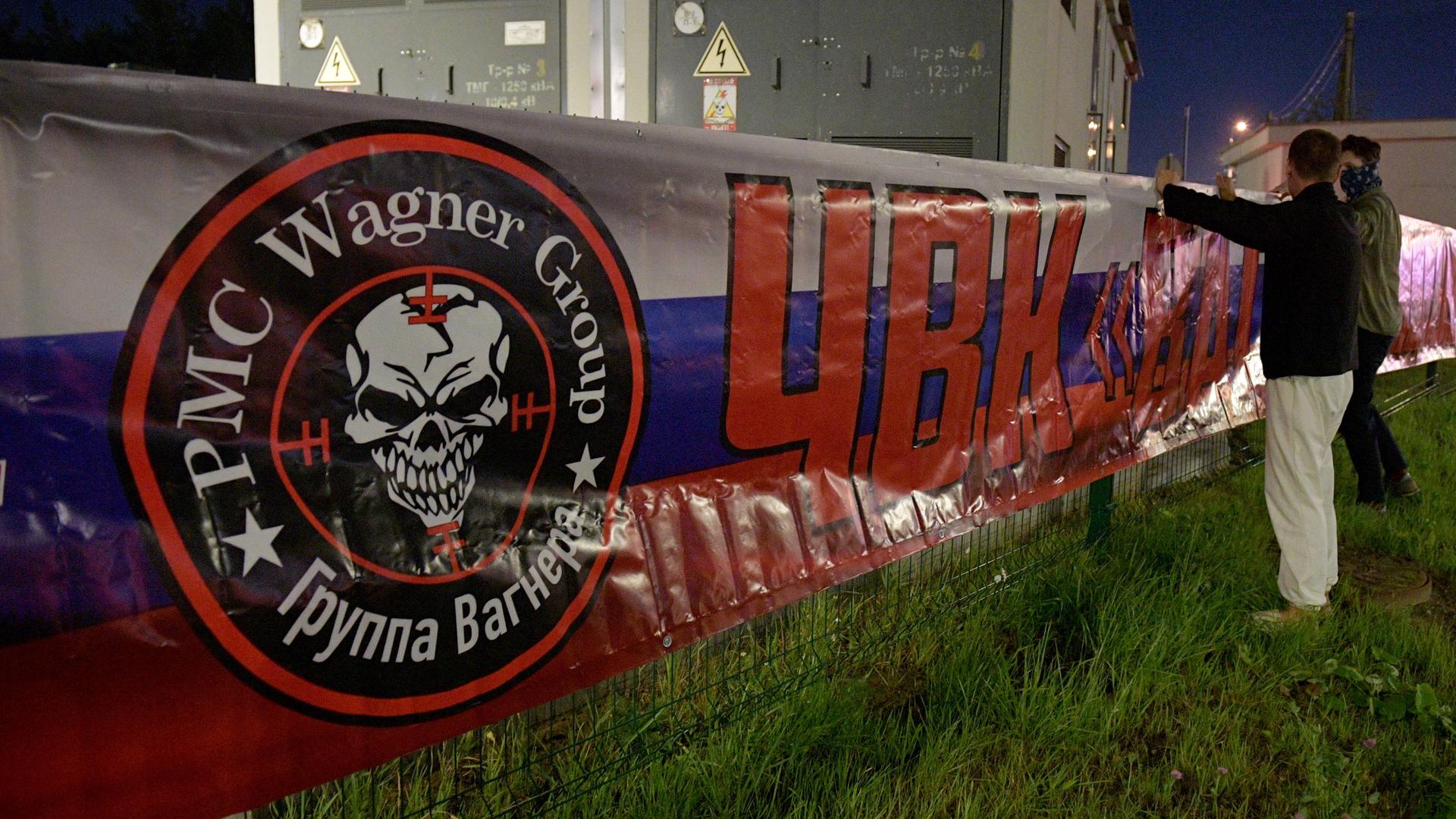 Vor der Zentrale der Gruppe "Wagner" in St. Petersburg ist ein Banner in den Farben der russischen Trikolore aufgehängt. Darauf ist das Loge der Gruppe.