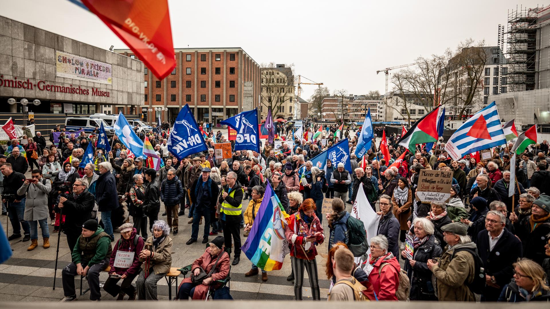 Mehrere Hundert Menschen versammeln sich unter dem Motto "Für eine zivile Zeitenwende - Kriege beenden, Aufrüstung stoppen!" auf dem Kölner Roncalliplatz zum Ostermarsch.