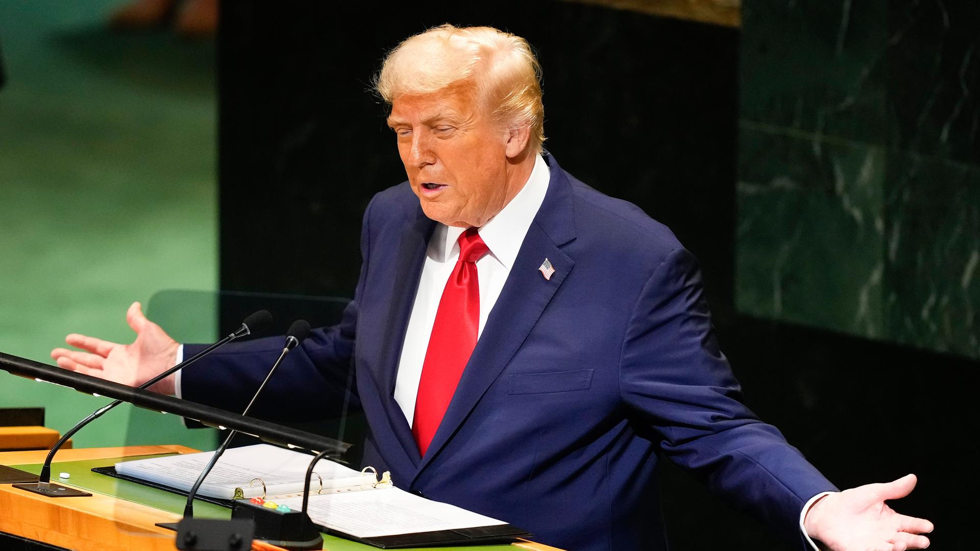 Trump steht am Rednerpult vor der Marmorwand des UNO-Präsidiums, sagt etwas und breitet beide Arme aus. 