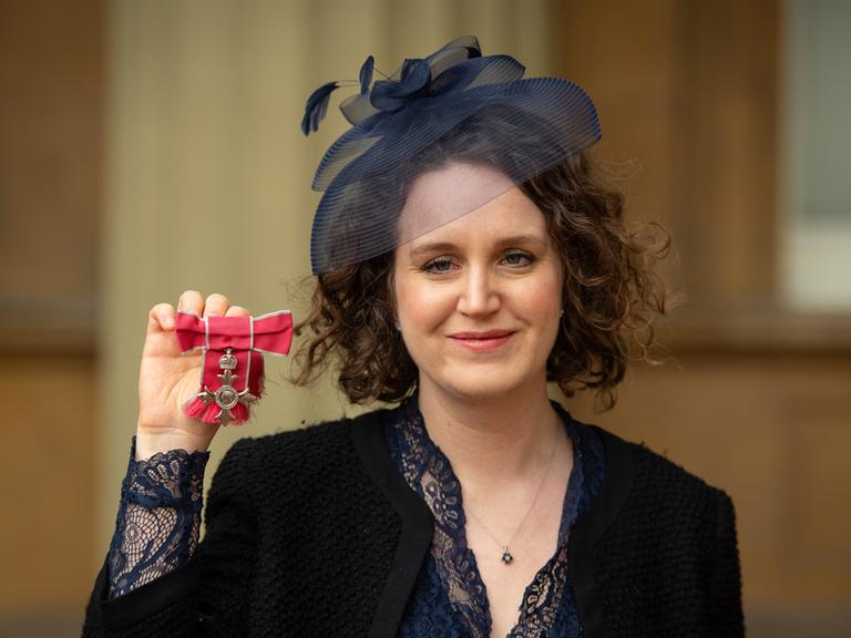 Komponistin Helen Grime zeigt ihre MBE-Medaille 