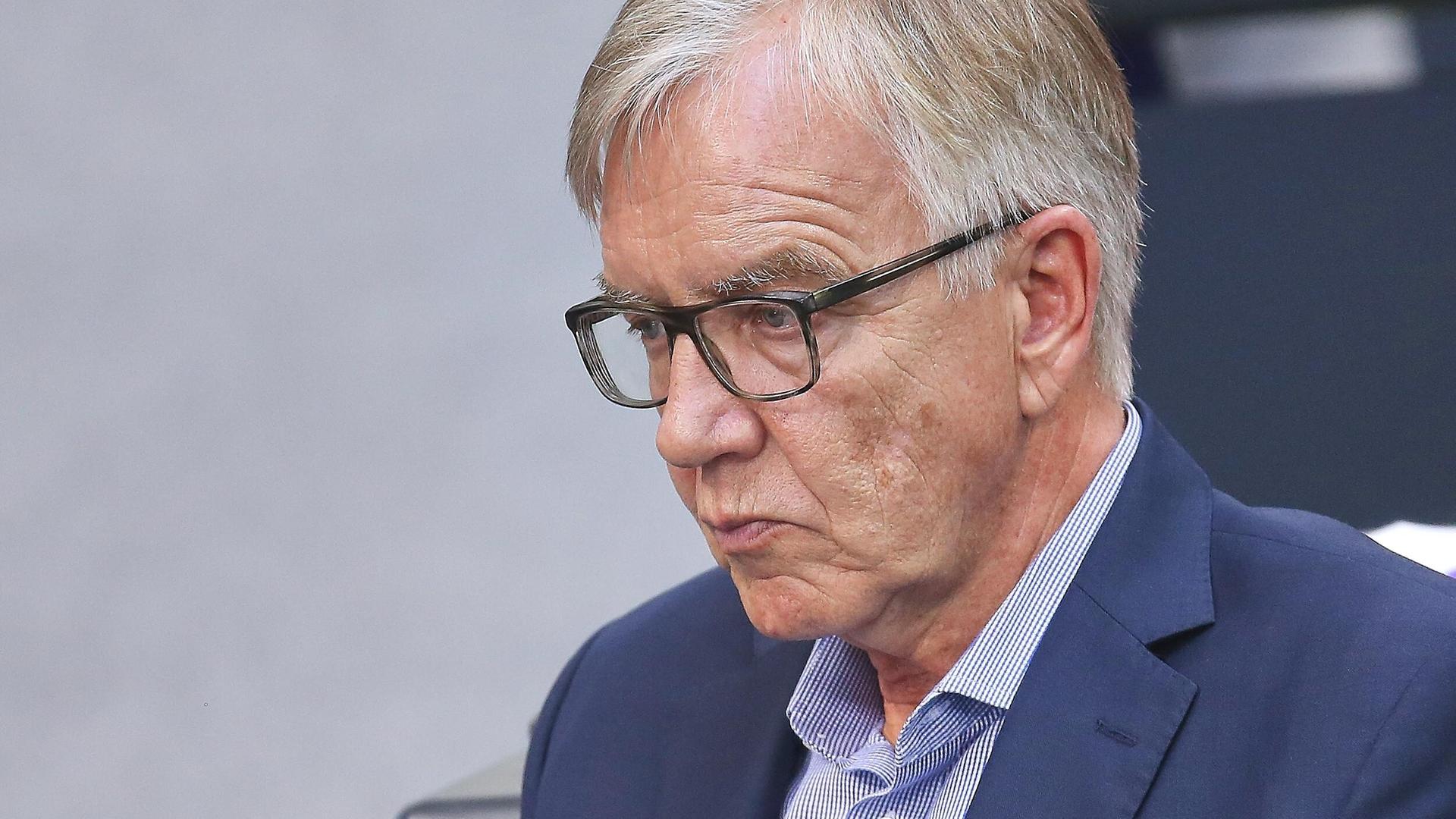 Dietmar Bartsch steht im Bundestag, trägt Sakko, Hemd und Brille und schaut nachdenklich ernst zu Boden. Dietmar Bartsch steht im Bundestag, trägt Sakko, Hemd und Brille und schaut nachdenklich ernst zu Boden.