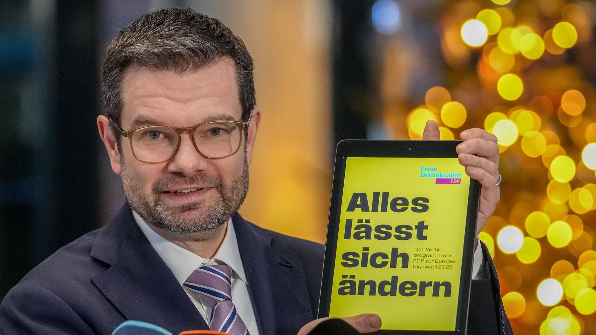 Marco Buschmann, designierter FDP-Generalsekretär, hält ein Tablet, auf dem der Schriftzug "Alles lässt sich ändern", in der Hand.