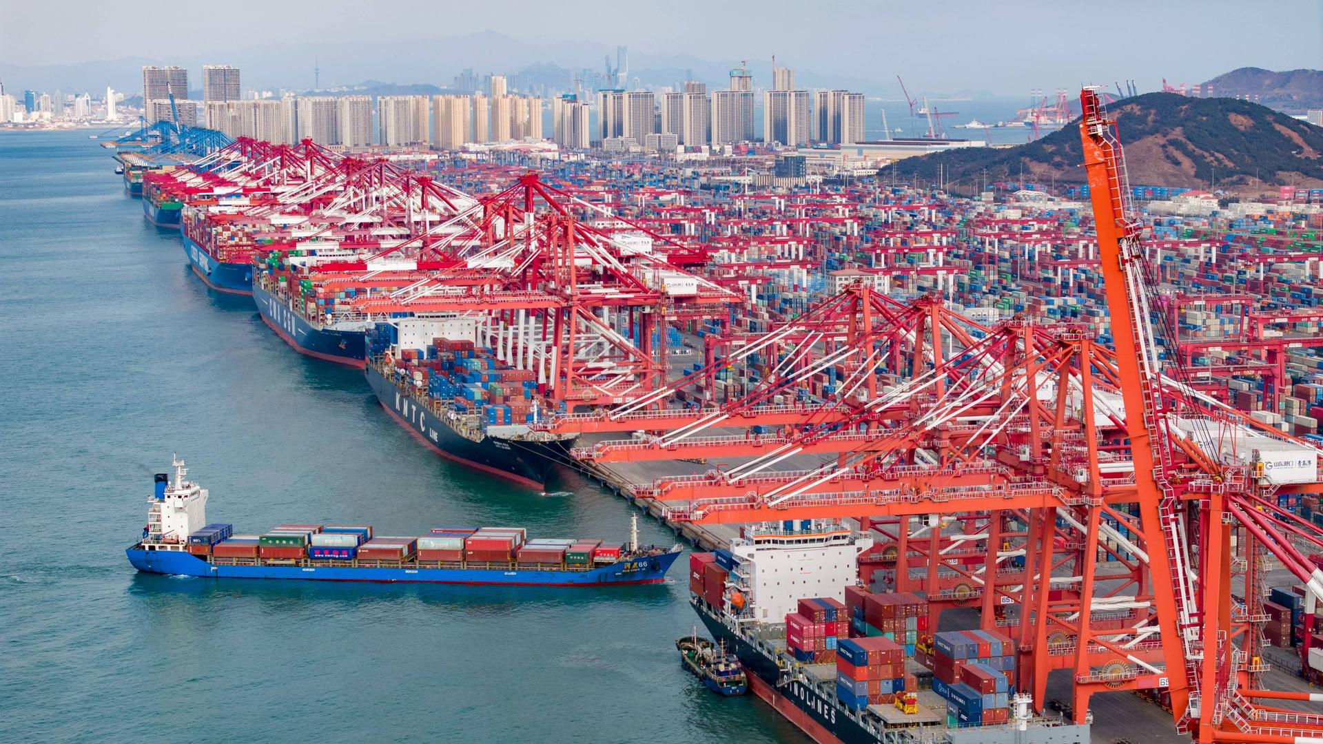 Blick auf den Qianwan Container Terminal des Hafens Qingdao in der Provinz Shandong in China. Container werden be- und entladen.