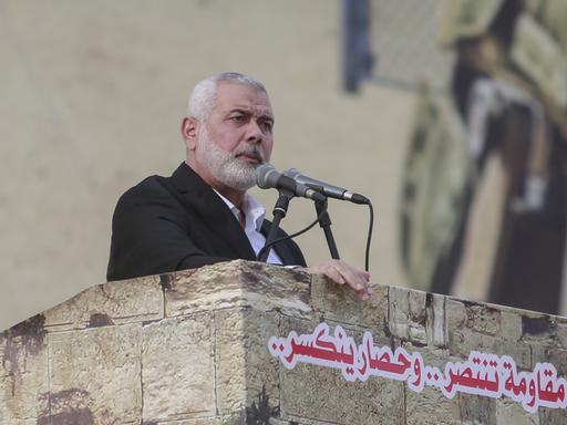 Hamas-Chef Ismail Hanija steht mit ernstem Blick an einem Rednerpult aus Stein vor Mikrofonen.