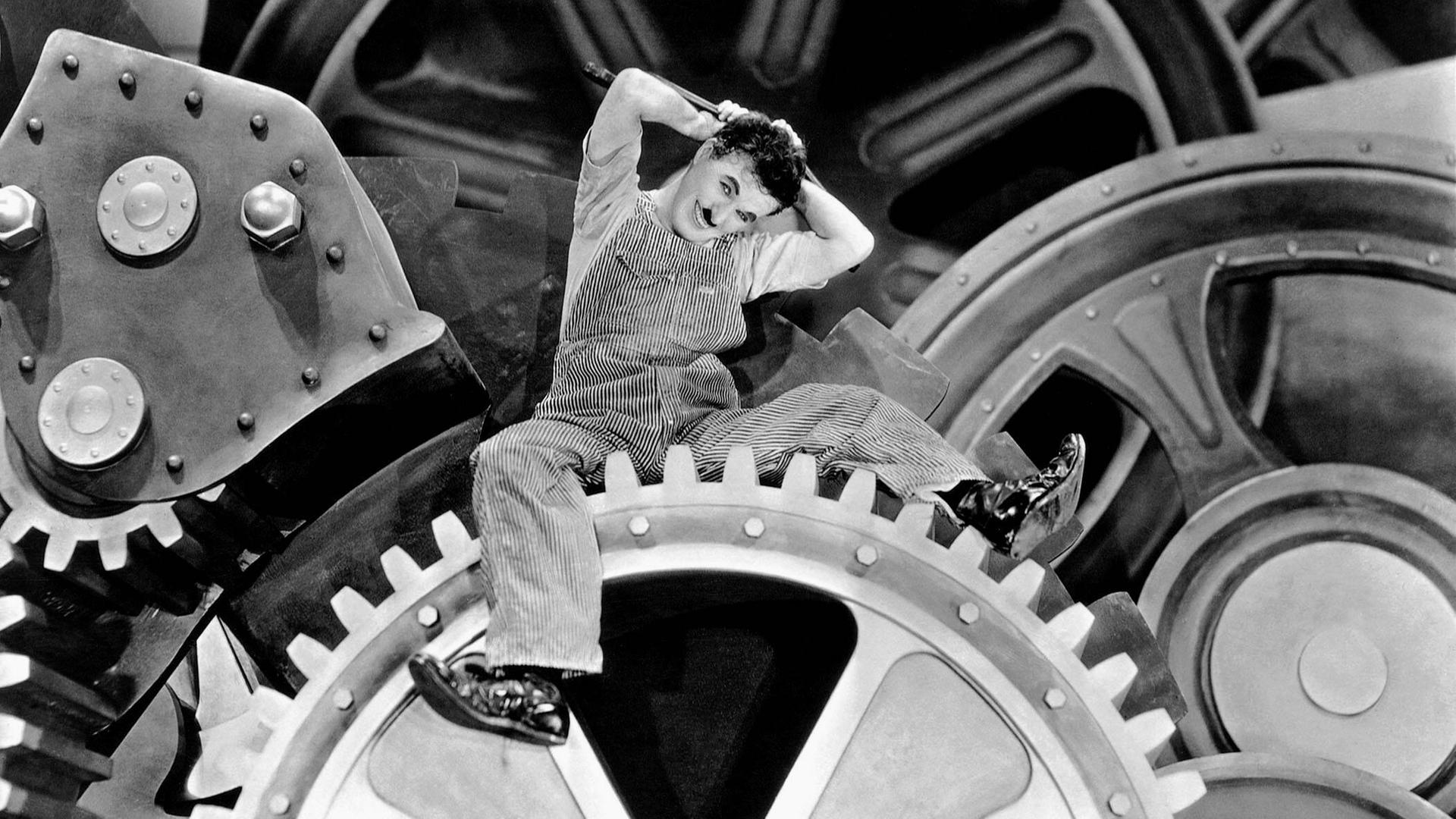 Charles Chaplin auf einem Zahnrad im Film "Moderne Zeiten".
