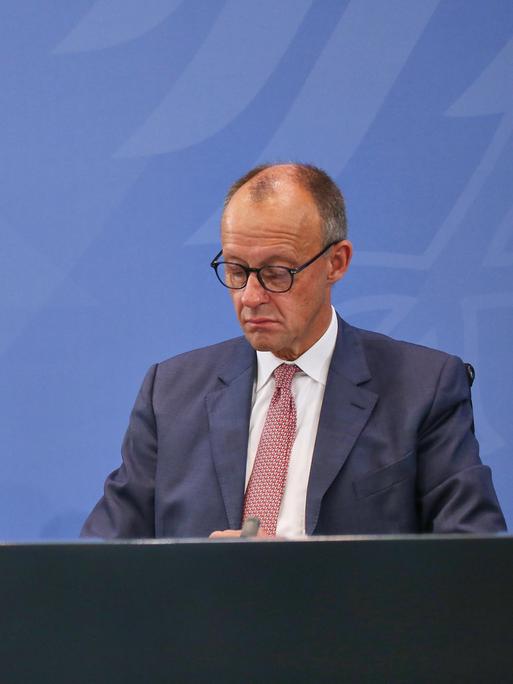 Auf einem Podium sitzen zwei Männer und schauen gelangweilt drein. Der eine trägt einen schwarzen, der andere einen dunkelblauen Anzug. Rechts sitzt Markus Söder von der CSU, links Bundeskanzler Friedrich Merz von der CDU. Auf einem Podium sitzen zwei Männer und schauen gelangweilt drein. Der eine trägt einen schwarzen, der andere einen dunkelblauen Anzug. Rechts sitzt Markus Söder von der CSU, links Bundeskanzler Friedrich Merz von der CDU.