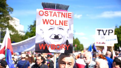 Ein Mann hält ein Plakat in die Höhe, auf dem der Chef der rechtsnationale Regierungspartei PiS, Jaroslaw Kaczynski, zu sehen ist