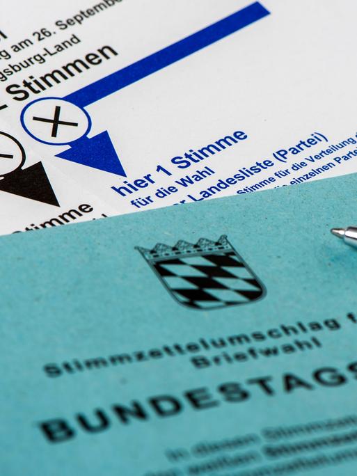 Ein Umschlag mit der Aufschrift "Stimmzettelumschlag für die Briefwahl" liegt auf einem Stimmzettel. Beides ist im Ausschnitt zu sehen.