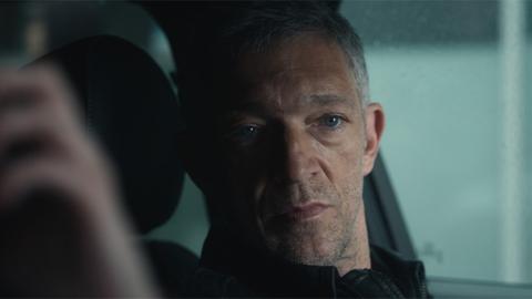 Szene mit Vincent Cassel in der Serie „Liaison“. Er sitzt in einem Auto und guckt in Richtung des Beifahrers bzw. der Beifahrerin.