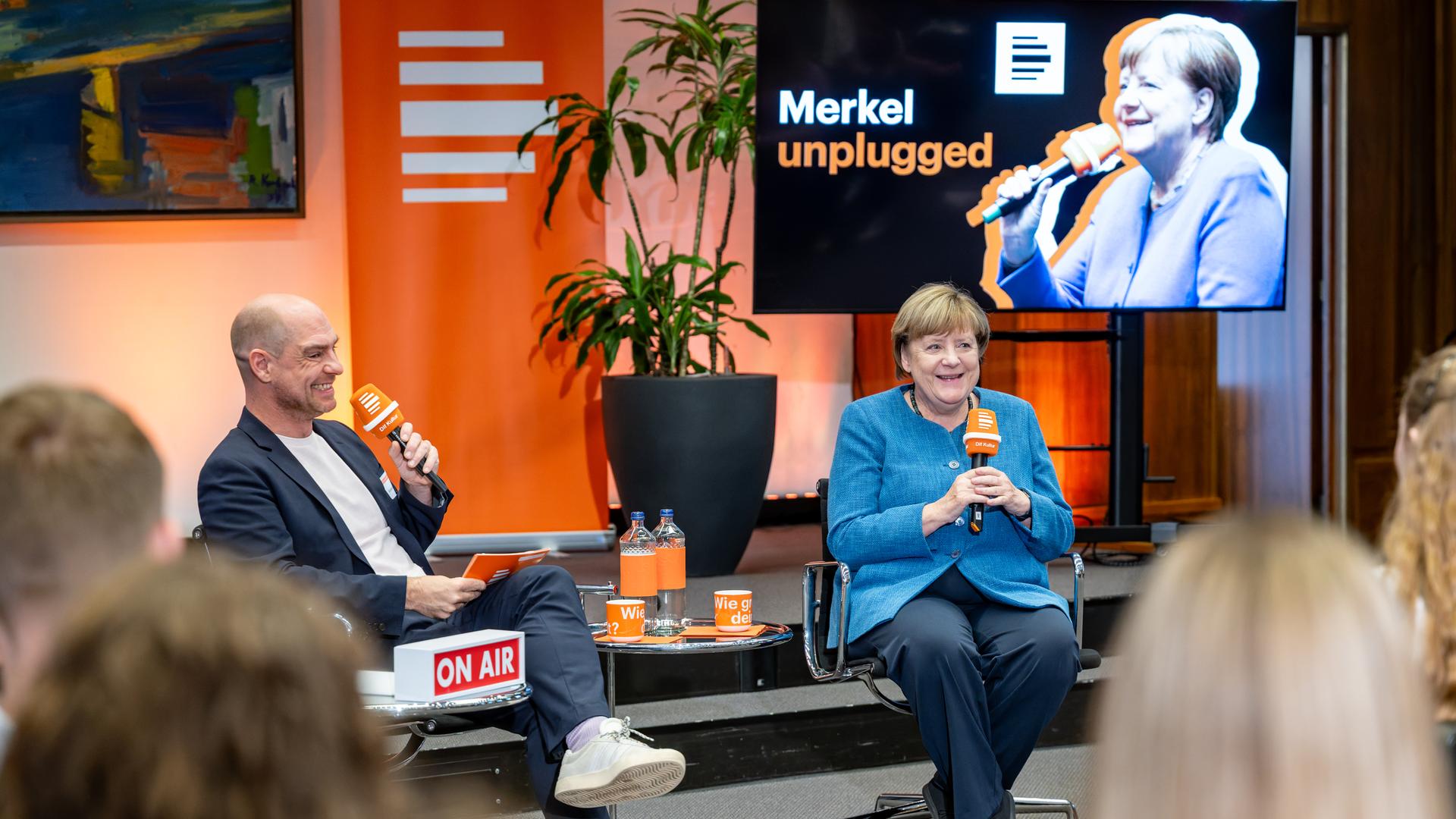 Die ehemalige Bundeskanzlerin Angela Merkel spricht in ein Mikrofon von Deutschlandfunk Kultur. 