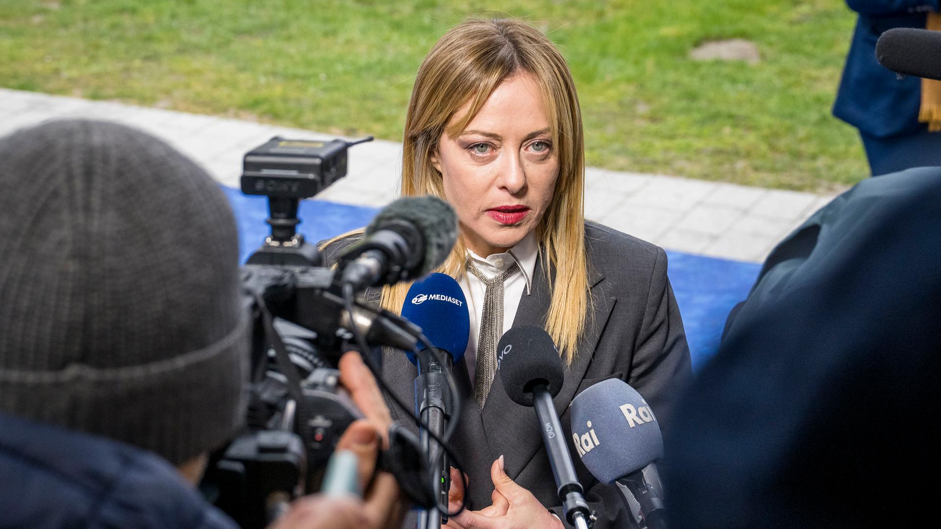 Italiens Ministerpräsident Meloni steht vor Journalisten und gibt ein Statement.