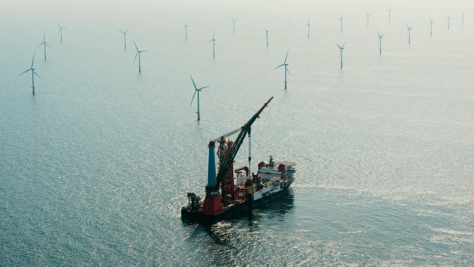 Luftaufnahme eines Installationsschiffes beim Bau eines Windrads in einem Offshore-Windpark.