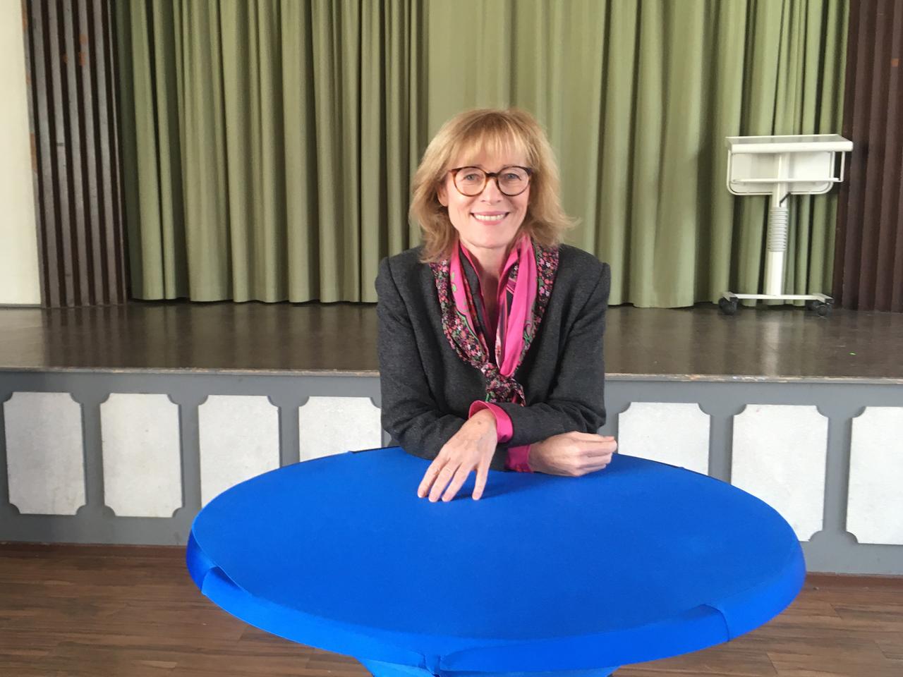 Karin Welge posiert hinter einem Stehtisch für ein Foto. 