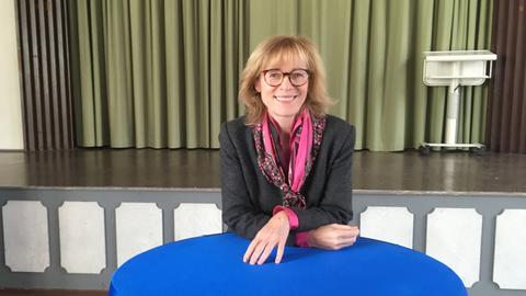 Karin Welge posiert hinter einem Stehtisch für ein Foto.