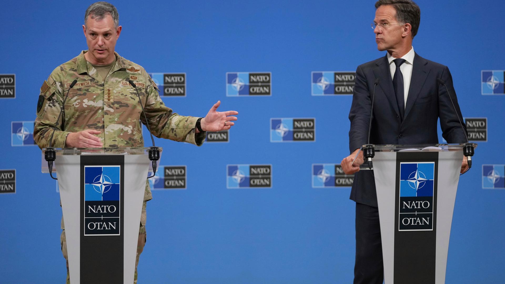 NATO-Generalsekretär Rutte und der Oberbefehlshaber der alliierten Streitkräfte in Europa, Grynkewich, stehen an Rednerpulten nebeneinander. Grynkewich, der eine Tarnuniform trägt, gestikuliert mit einer Hand. NATO-Generalsekretär Rutte und der Oberbefehlshaber der alliierten Streitkräfte in Europa, Grynkewich, stehen an Rednerpulten nebeneinander. Grynkewich, der eine Tarnuniform trägt, gestikuliert mit einer Hand.