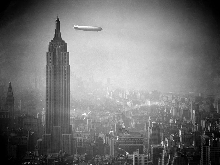 Ein Zeppelin schwebt am Empire State Building vorbei über Manhattan.