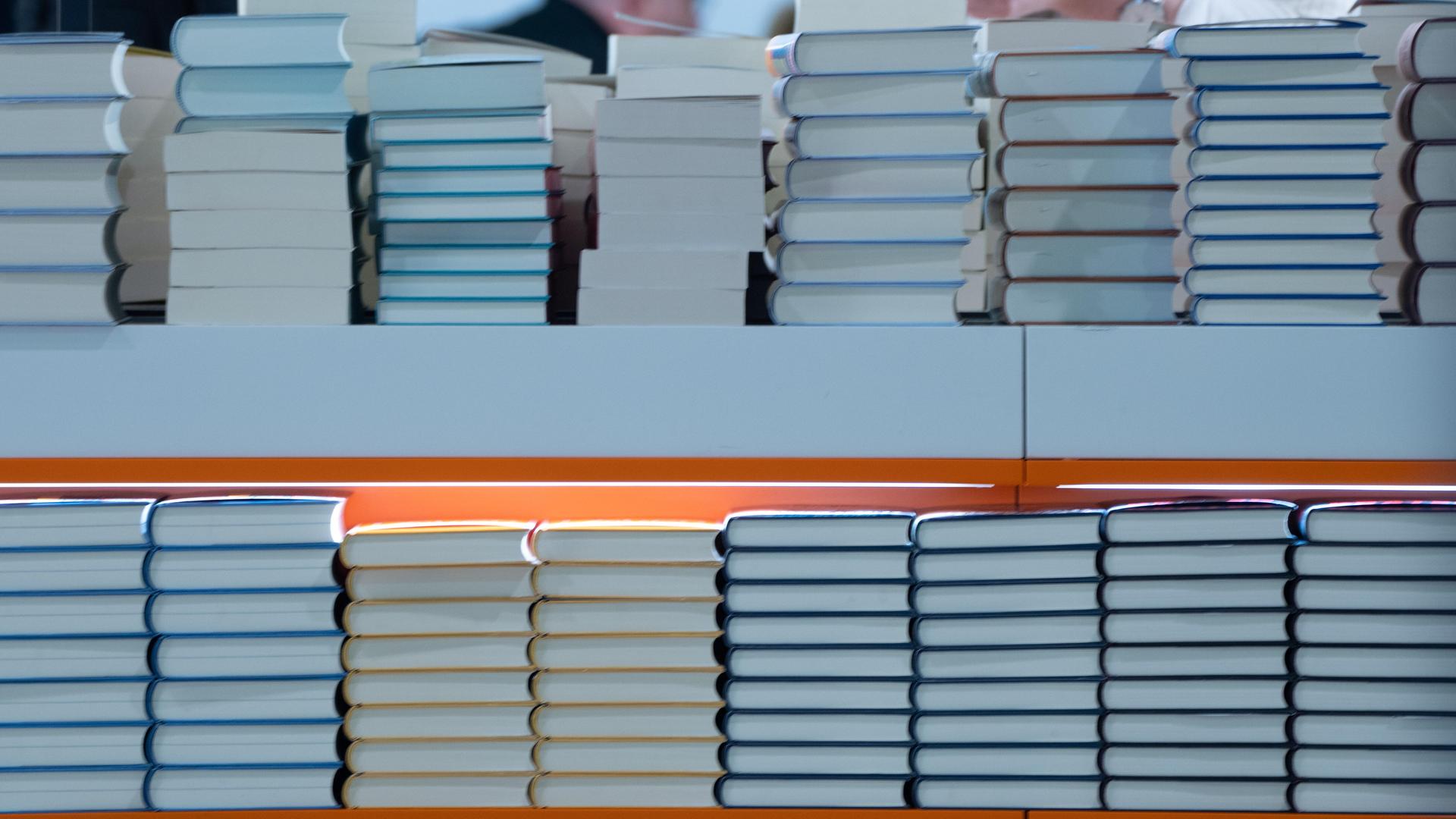 In einem Regal liegen Stabel von Büchern. Es ist ein Foto von einer Buchmesse. In einem Regal liegen Stabel von Büchern. Es ist ein Foto von einer Buchmesse.