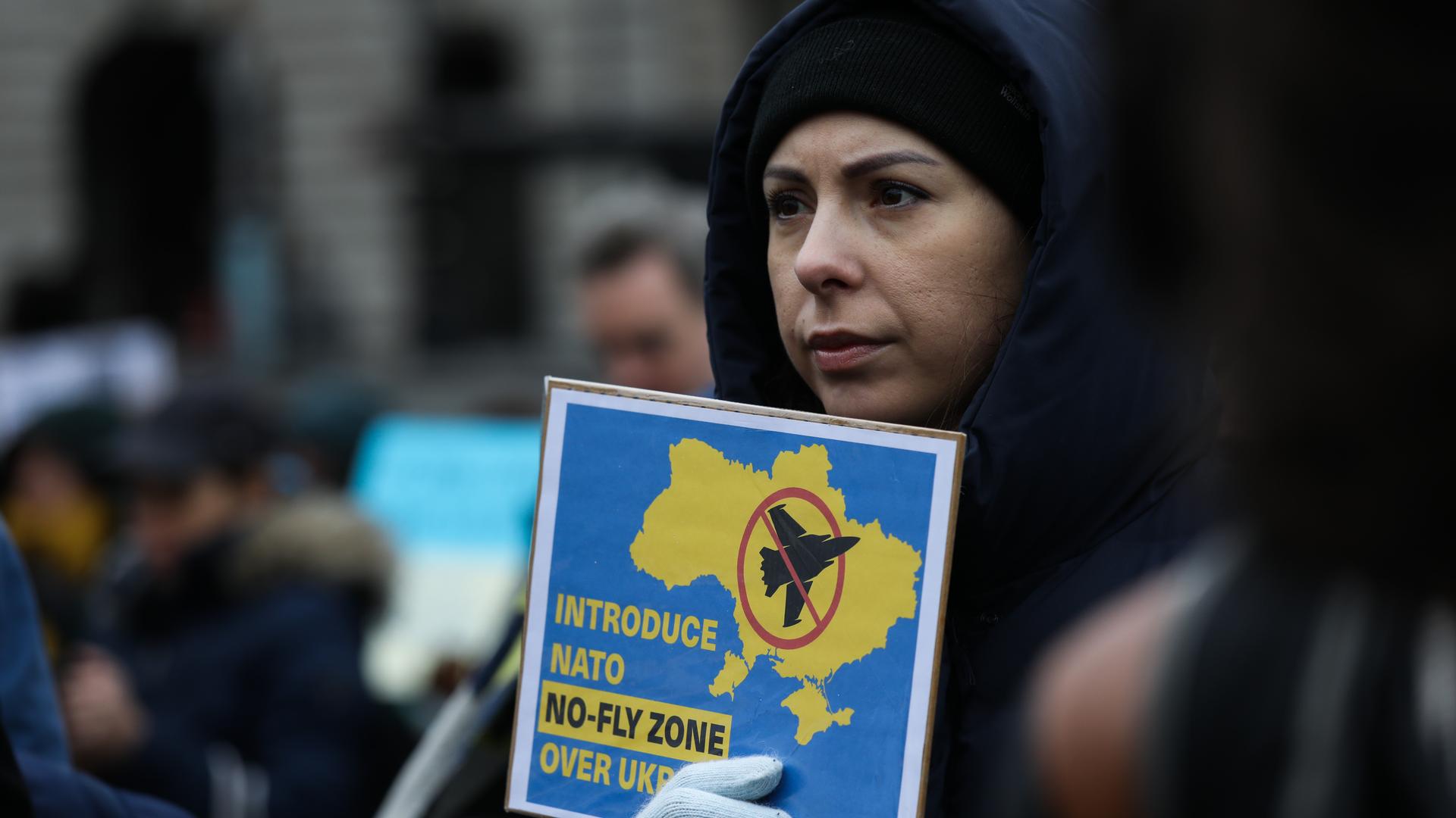 Eine Frau hält ein Schild, auf dem ein Eingreifen der NATO zur Durchsetzung einer Flugverbotszone gefordert wird, während Tausende am 5. Februar 2022 auf dem Trafalgar Square in London, Vereinigtes Königreich, für den Frieden in der Ukraine demonstrieren. 