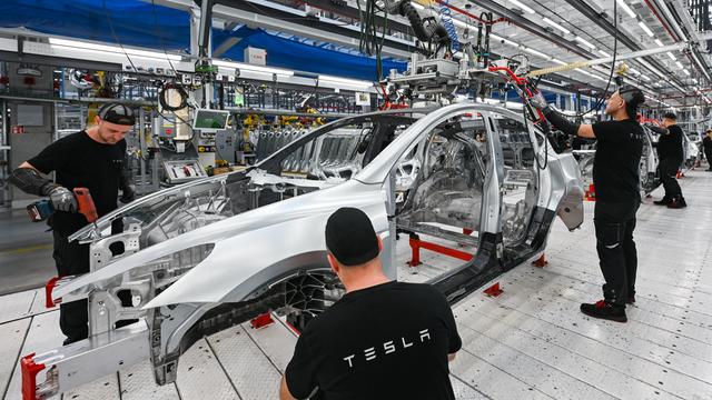 Arbeiter montieren in der Produktionshalle der Tesla-Gigafactory in Grünheide (Brandenburg) ein Elektrofahrzeug vom Typ Tesla Model Y.