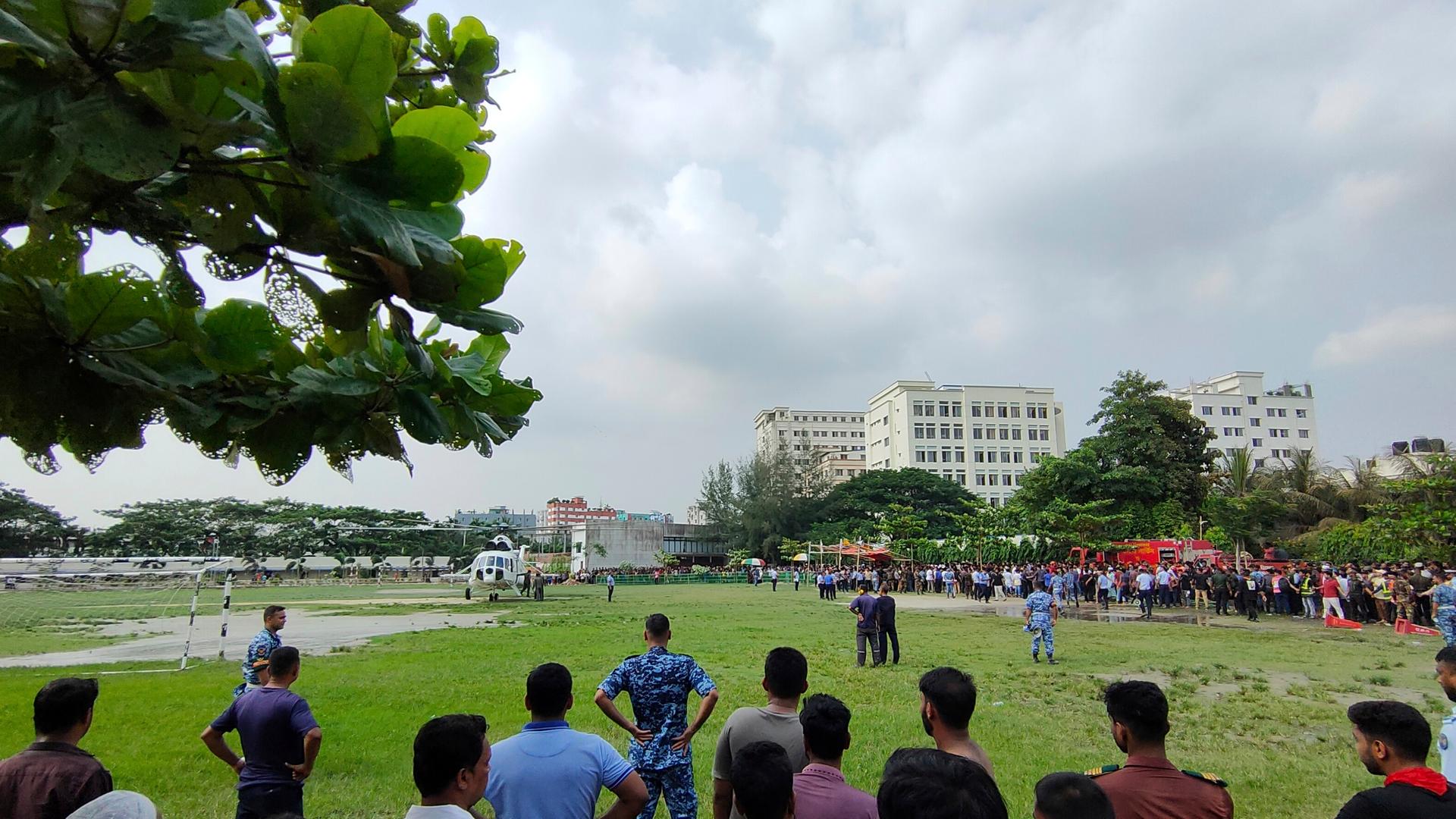Dhaka: Menschen versammeln sich an der Absturzstelle eines Trainingsflugzeugs der Bangladesch Air Force auf ein Schulgelände. 