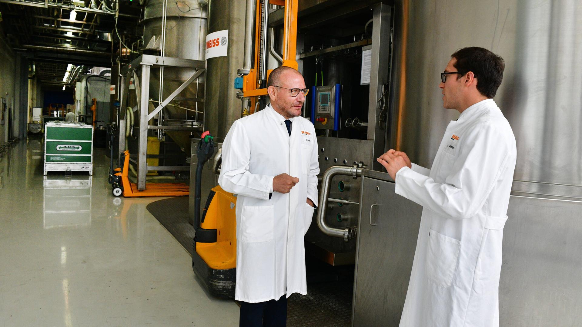 Giuseppe Nardi und Jonas Thielmann (v.l.) unterhalten sich in der Produktion der Firma Dr. Theiss Naturwaren GmbH in Homburg.