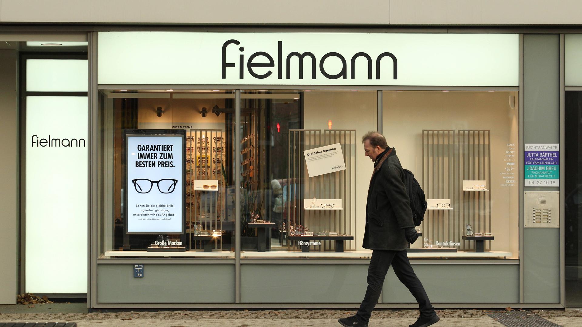 Ein Mann geht am Schaufenster einer Filiale der Optikerkette Fielmann vorbei.