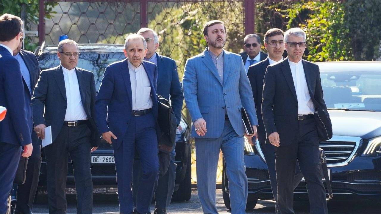 Vertreter einer iranischen Delegation gehen zum Verhandlungsort in in Genf.