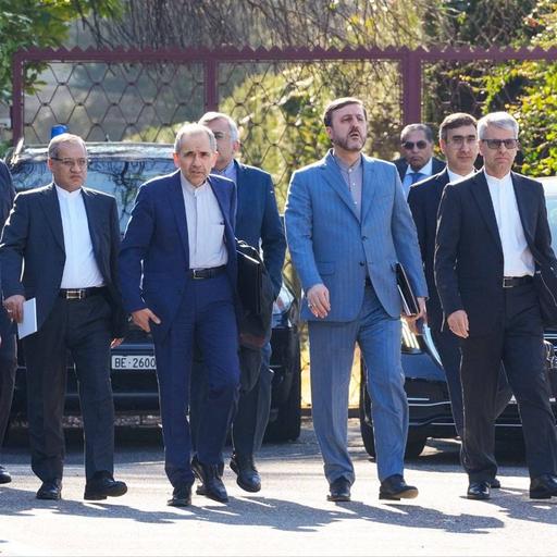 Vertreter einer iranischen Delegation gehen zum Verhandlungsort in in Genf.