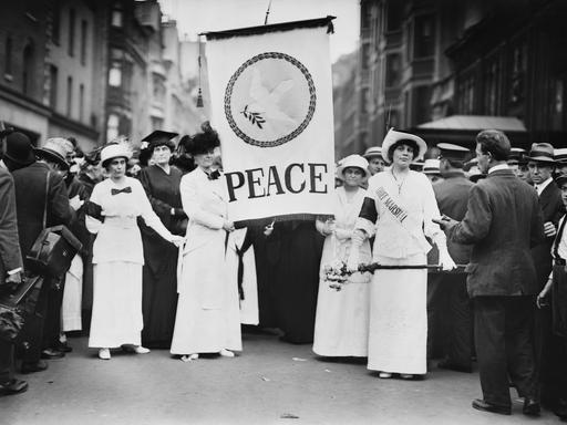 Friedensaktivistinnen protestieren Ende August 1914 in New York gegen den Ersten Weltkrieg. Frauen halten ein Banner mit der Aufschrift „Peace“ – „Frieden“ in der Hand. 