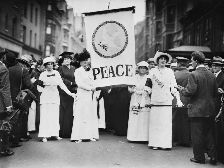 Friedensaktivistinnen protestieren Ende August 1914 in New York gegen den Ersten Weltkrieg. Frauen halten ein Banner mit der Aufschrift „Peace“ – „Frieden“ in der Hand. Friedensaktivistinnen protestieren Ende August 1914 in New York gegen den Ersten Weltkrieg. Frauen halten ein Banner mit der Aufschrift „Peace“ – „Frieden“ in der Hand.