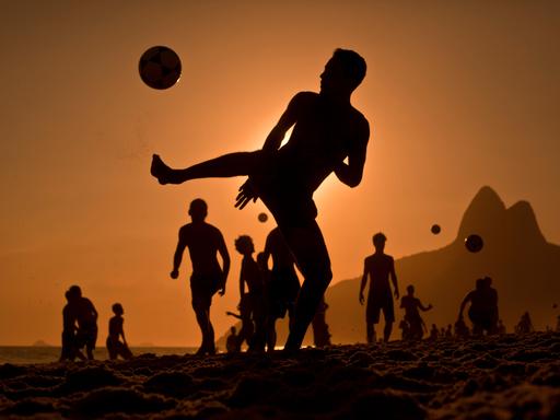 Junge Leute spielen am Strand von Rio Fußballl