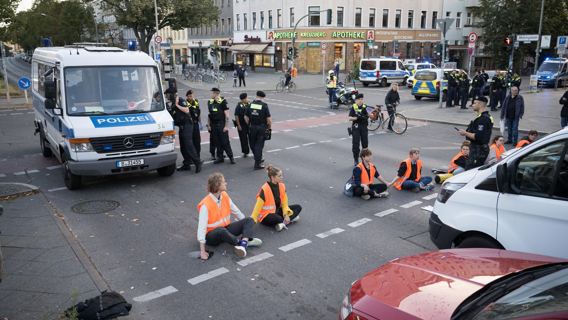 Berlin: Aktivisten der Klimaschutzgruppe Letzte Generation halten sich während einer Straßenblockade auf dem Mehringdamm an den Händen. 