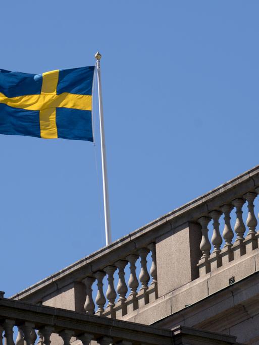 Die schwedische Flagge weht auf dem Reichstag in Stockholm. Wie die genauen Mehrheitsverhältnisse nach der Wahl aussehen, ist noch nicht ganz klar. 