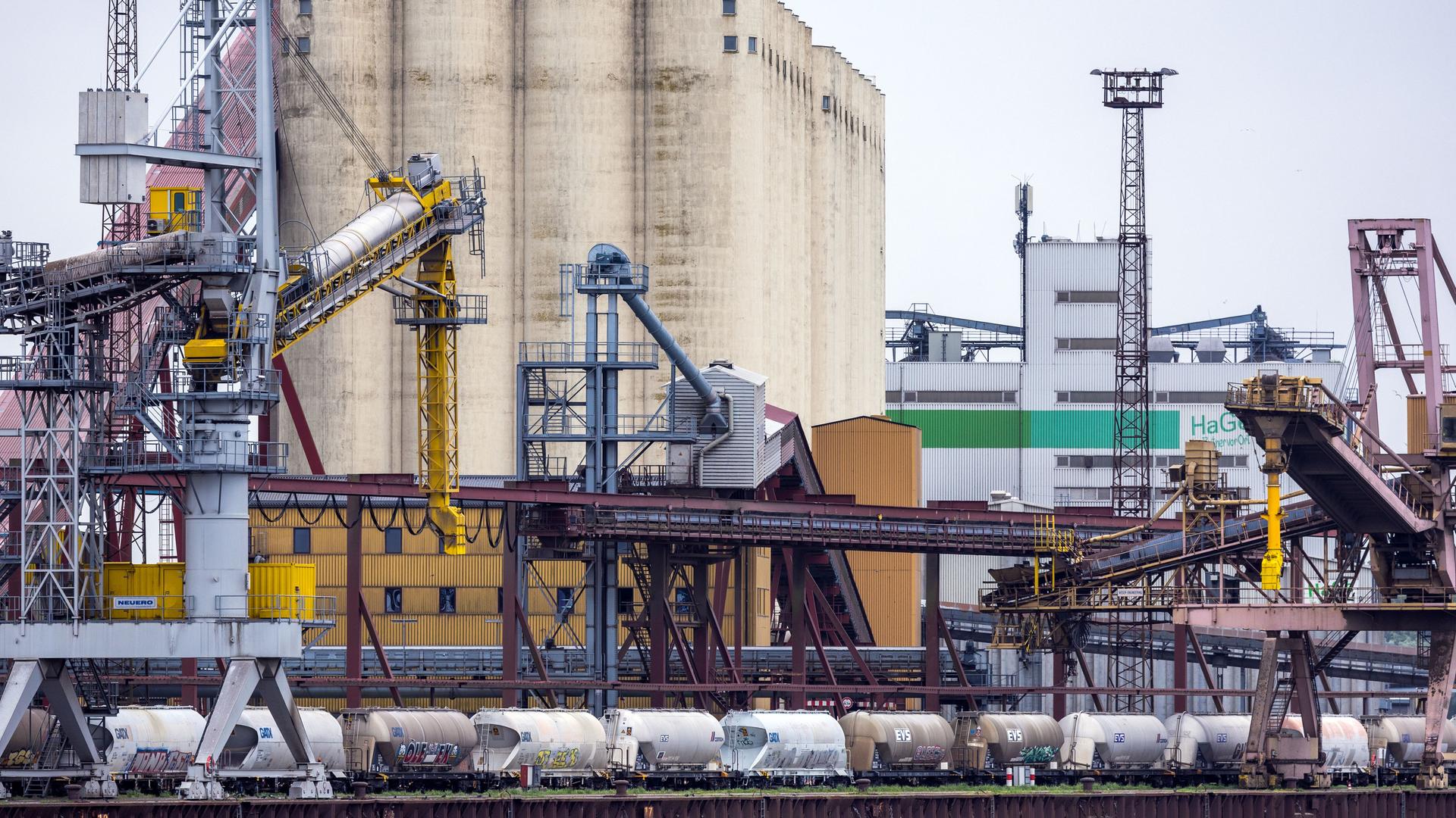 Vor einem großen Getreidesilo im Rostocker Seehafen stehen Eisenbahnwaggons auf dem Kai. Vor einem großen Getreidesilo im Rostocker Seehafen stehen Eisenbahnwaggons auf dem Kai.