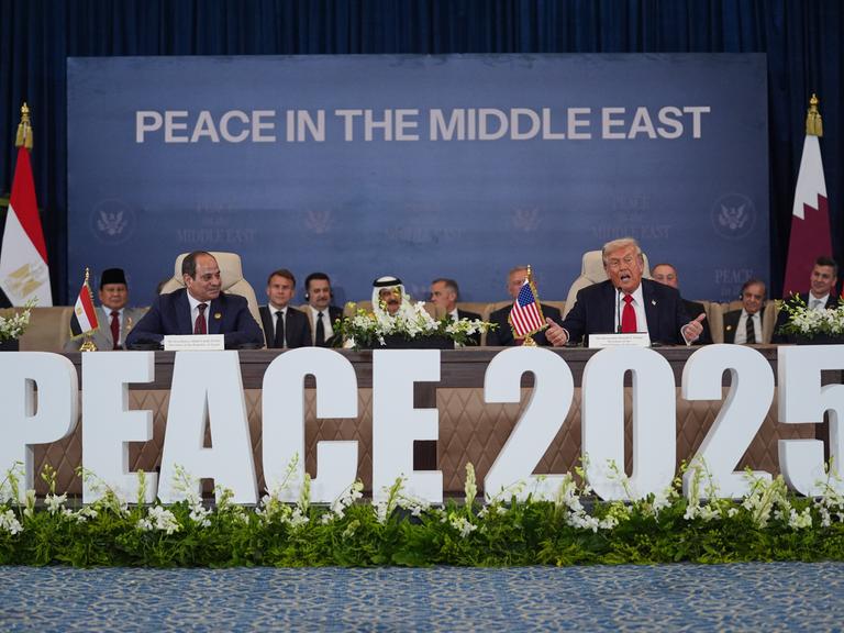 Präsident Donald Trump spricht im Beisein mehrerer Staats- und Regierungschefs auf der Gaza-Konferenz in Scharm el-Scheich. Vor dem Pult steht in großen Buchstaben das Wort "Peace 2025".

