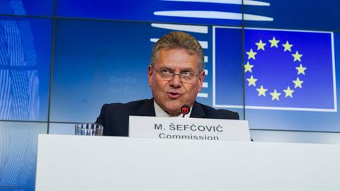 Kommissar für Handel und Wirtschaftliche Sicherheit, Sefcovic, sitzt hinter einem Rednerpult. Vor ihm steht sein Namensschild, hinter ihm an der Wand das Logo der EU.