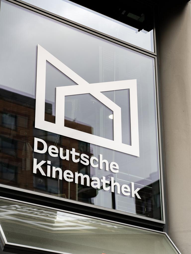 Blick auf eine Glasfassade mit dem Logo und dem Schriftzug der Deutschen Kinemathek.
