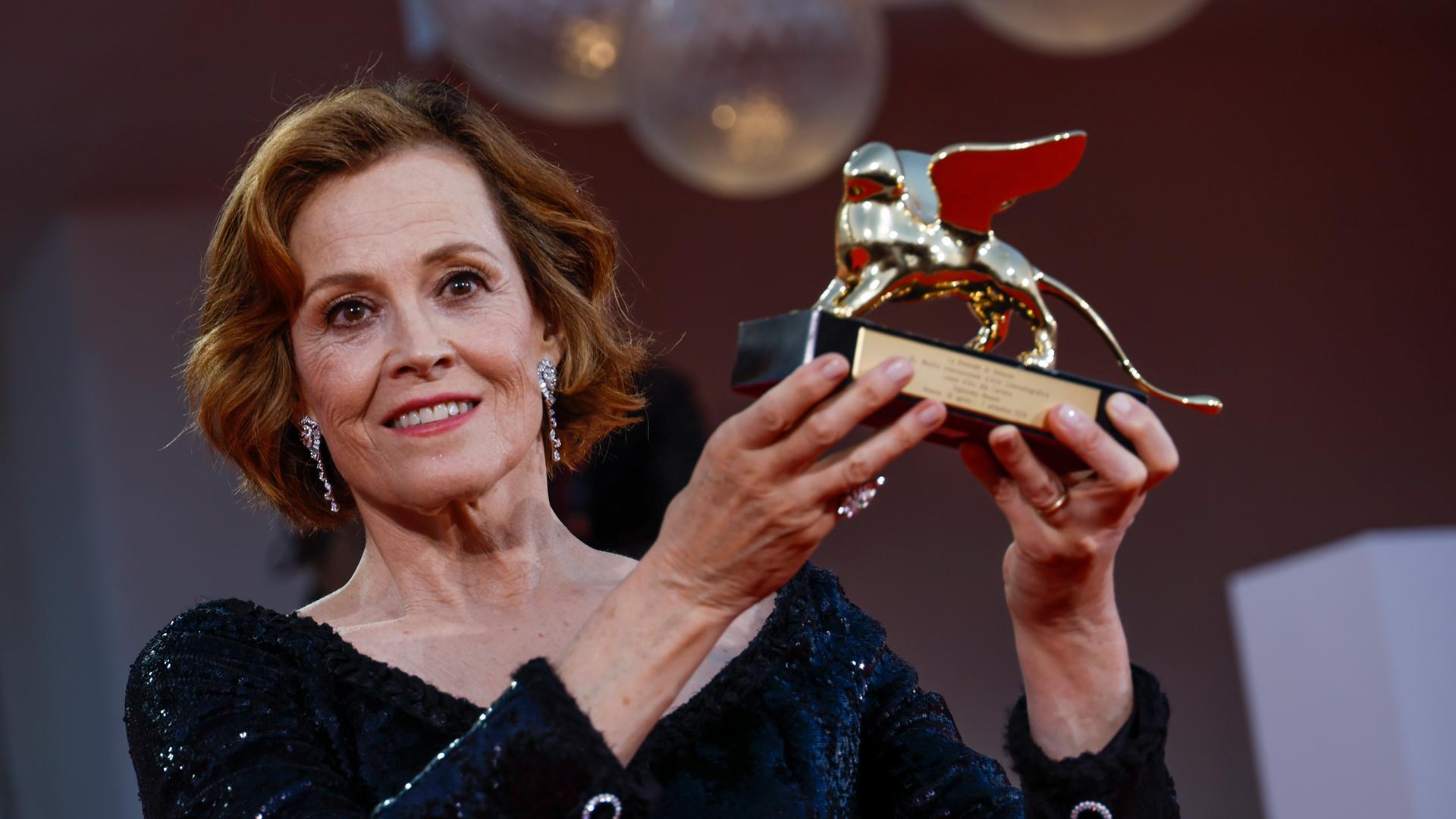 Schauspielerin Sigourney Weaver hält den Ehrenlöwen bei den Filmfestspielen von Venedig hoch