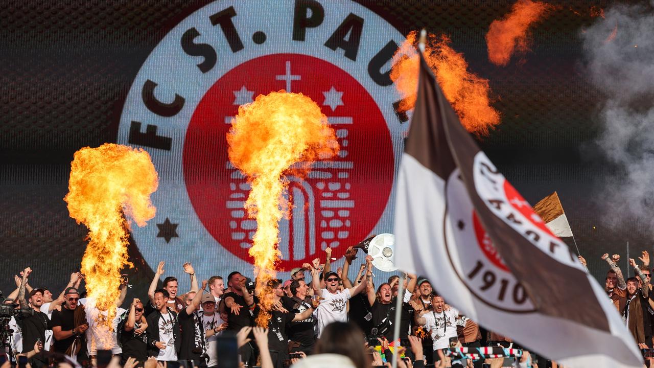 Aufstiegsfeier des FC St. Pauli: Jackson Irvine (mit Meisterschale) und die Mannschaft feiern auf der Bühne auf dem Spielbudenplatz auf der Reeperbahn. 