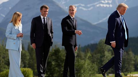 Georgia Meloni, Emmanuel Macron und Mark Carney verlassen hinter Donald Trump eine Bühne in den kanadischen Rocky Mountains