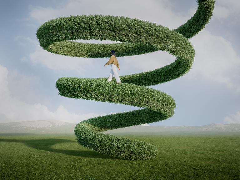 Eine Frau geht eine riesige grüne Spirale hinauf, die scheinbar im Himmel endet. 