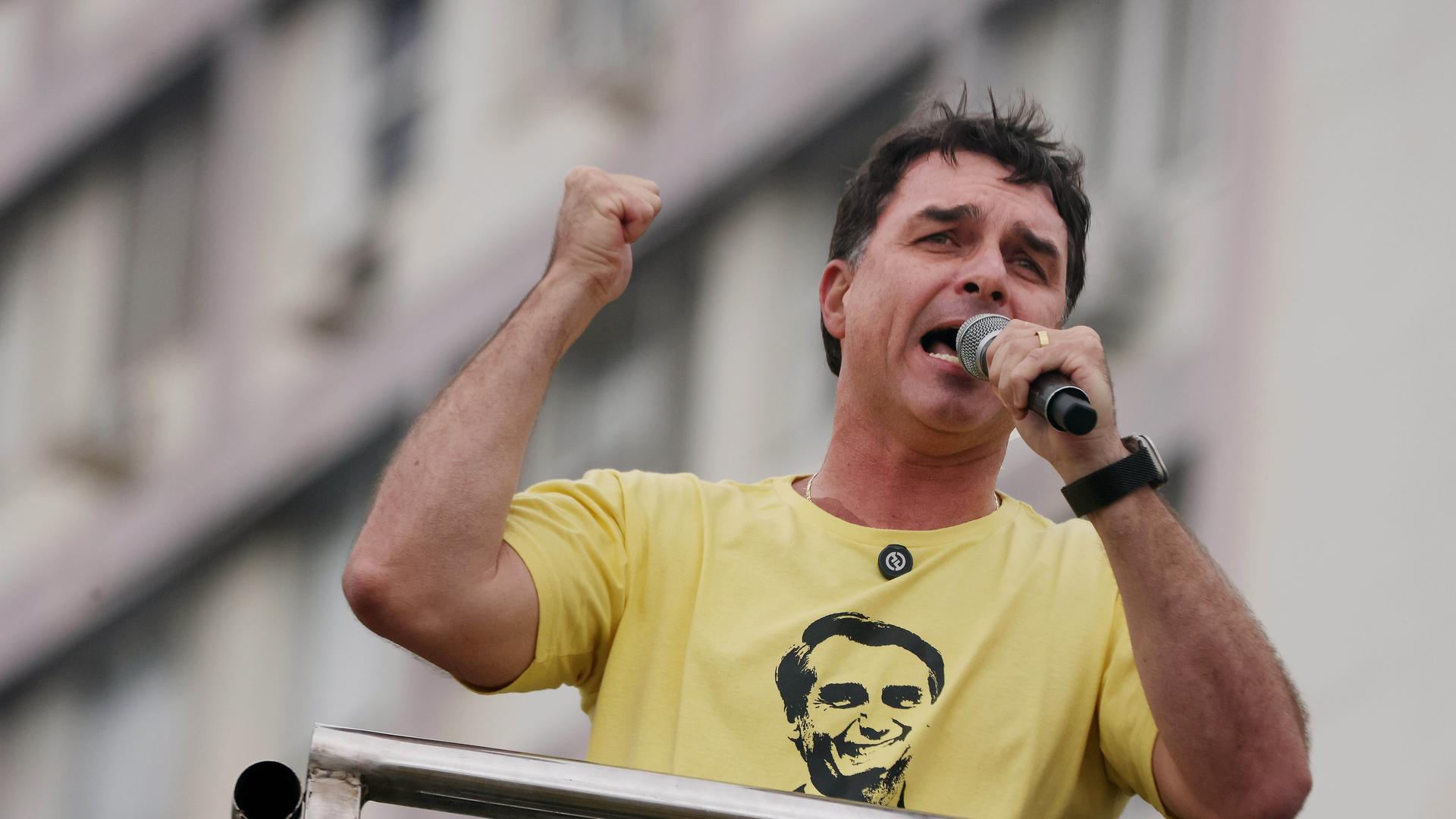 Senator Flavio Bolsonaro spricht energisch während einer Demonstration. Auf seinem T-Shirt ist das Gesicht seines Vaters. Senator Flavio Bolsonaro spricht energisch während einer Demonstration. Auf seinem T-Shirt ist das Gesicht seines Vaters.